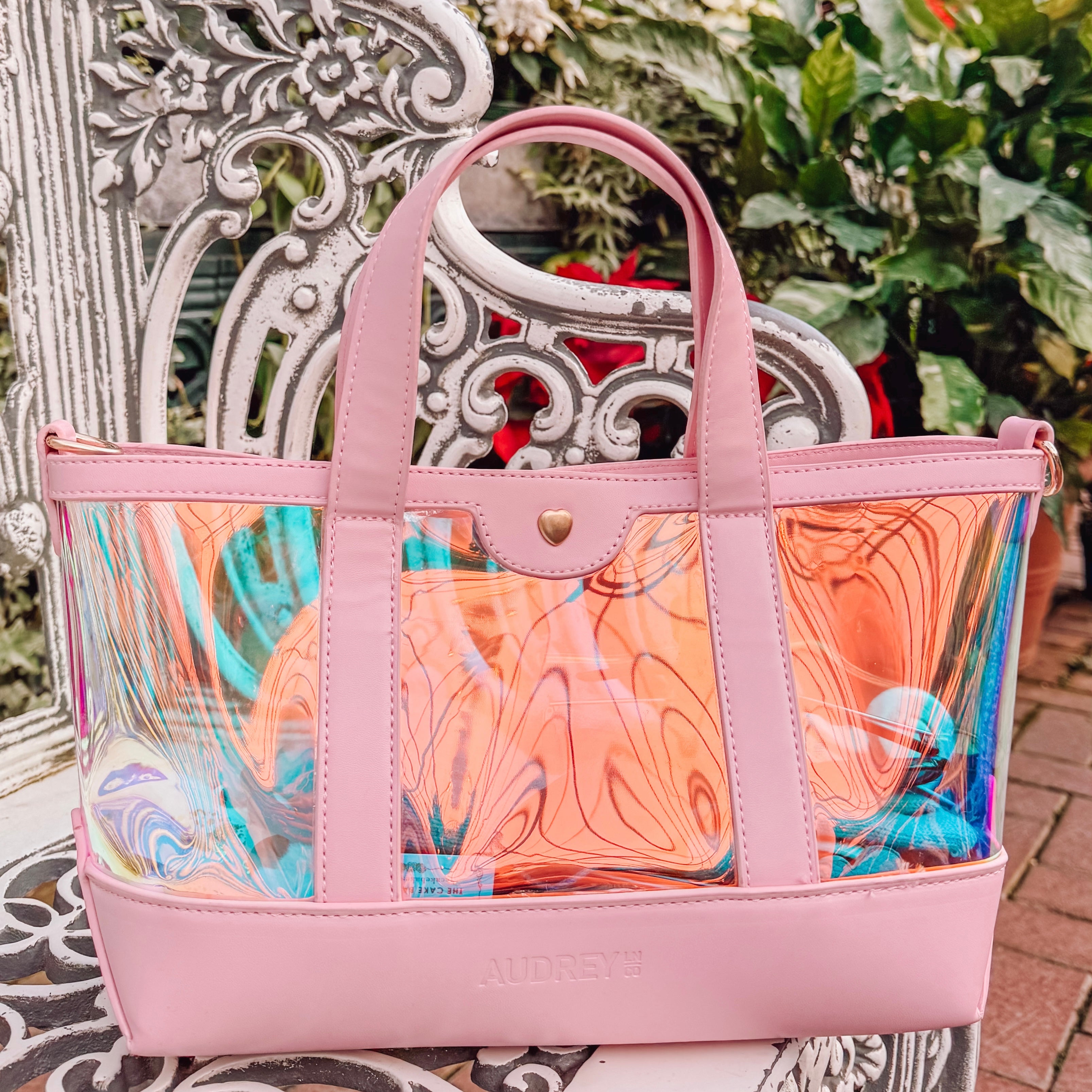 Pink handbag with colorful interior on a decorative chair