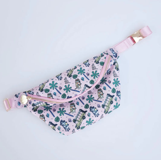 Fanny pack with pink straps and a pattern of green trees and blue roads on a light purple background