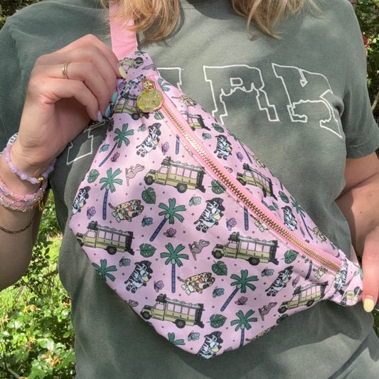 Woman holding a pink sling bag with vehicle pattern outdoors