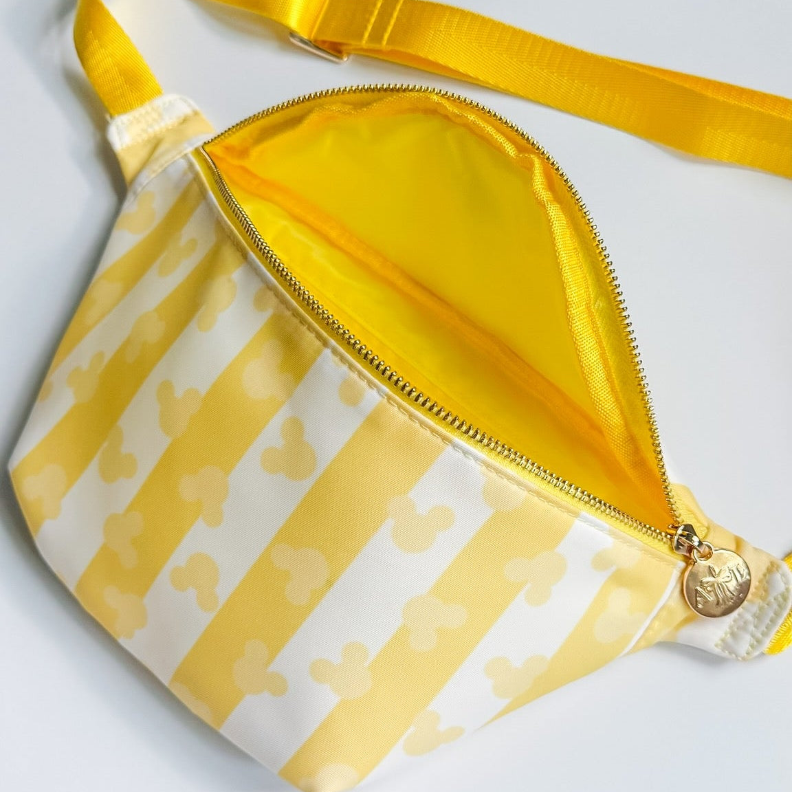 Yellow and white patterned fanny pack on a light gray background