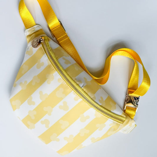 Fanny pack with yellow pattern and gold zipper on a light gray background