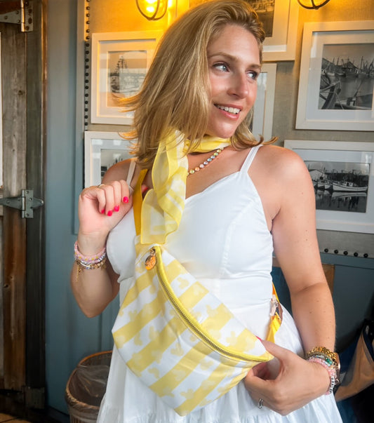 Woman in a white dress with a yellow striped bag in an indoor setting