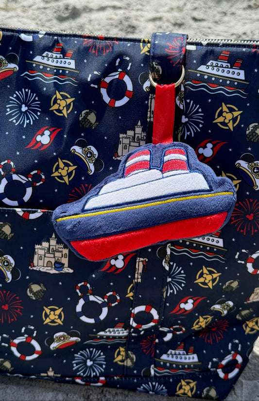 Navy blue bag with maritime-themed design and a ship-shaped plush bag charm.