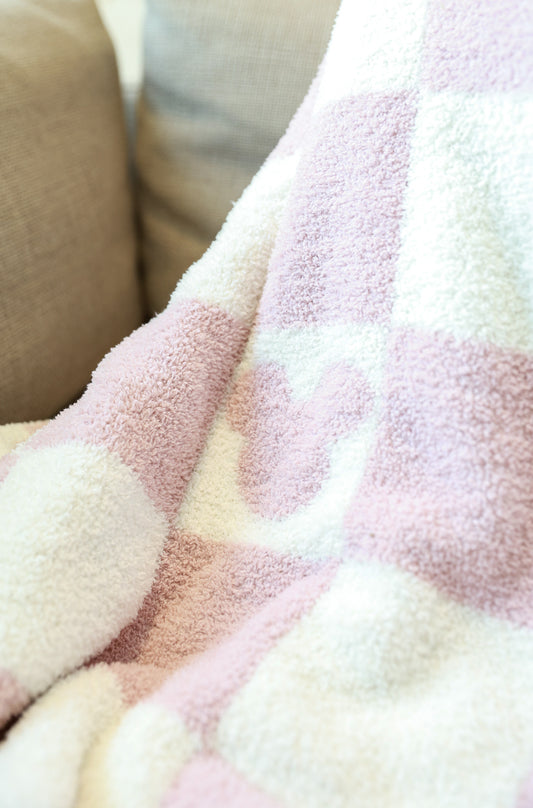 Close-up of a soft, textured fabric with pink and white checkered pattern.
