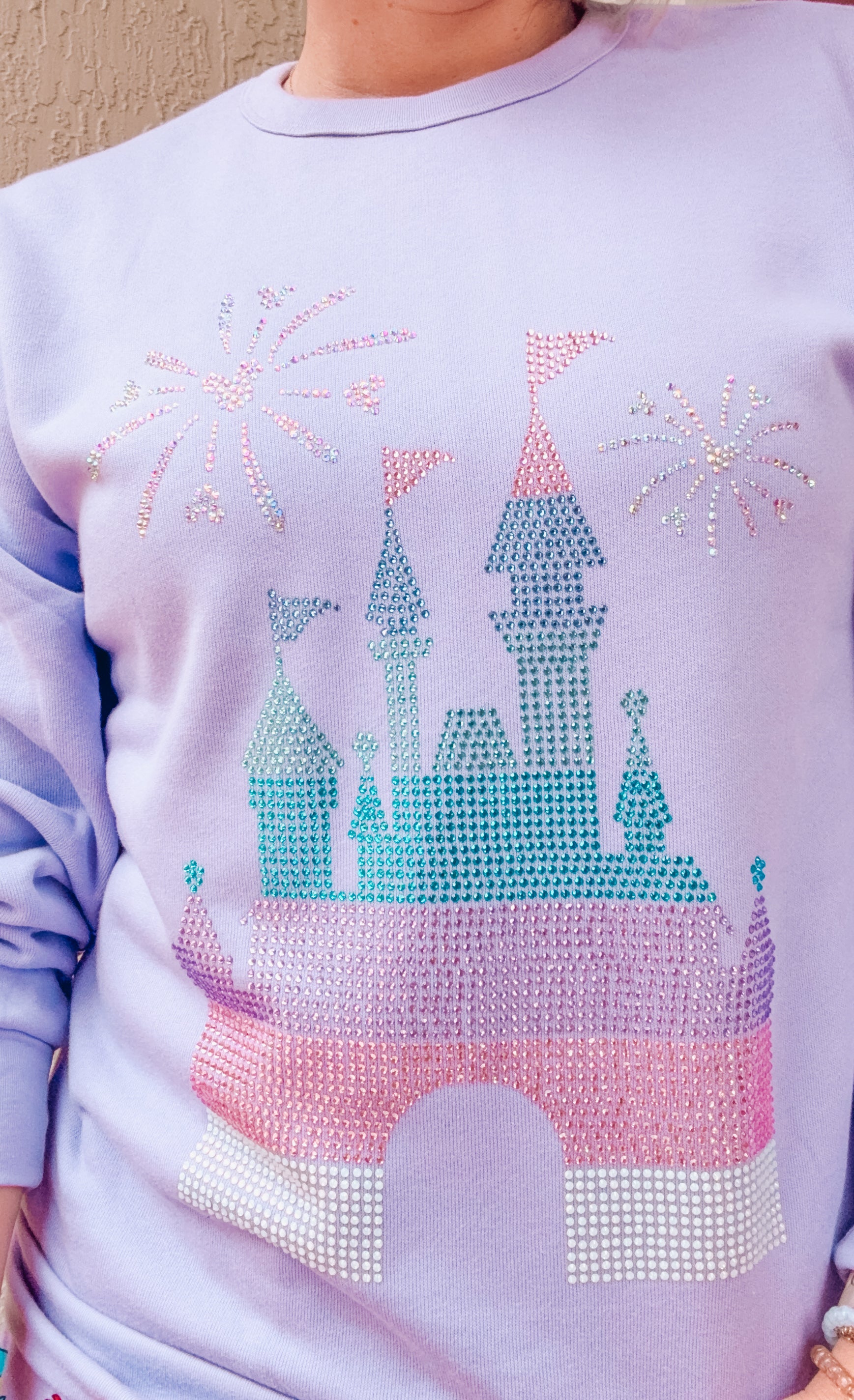 Light purple sweatshirt with a castle design made of rhinestones.