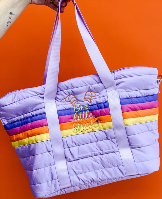 Purple quilted bag with rainbow stripes and text on an orange background