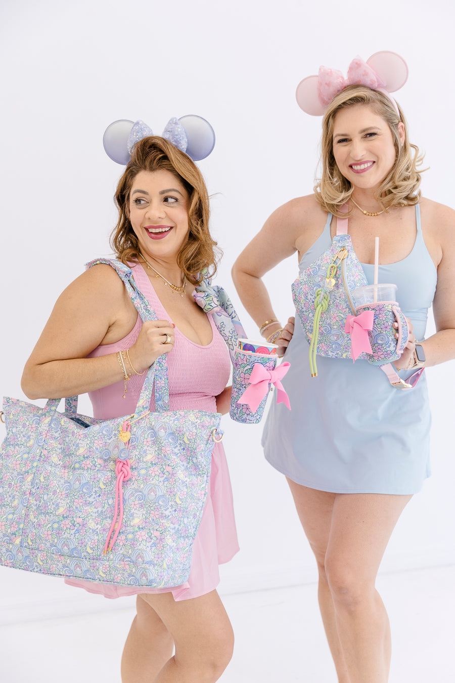 Two women holding matching bags and accessories with a floral print
