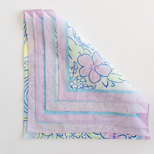 A floral scarf folded into loose fourths so each corner is visible.