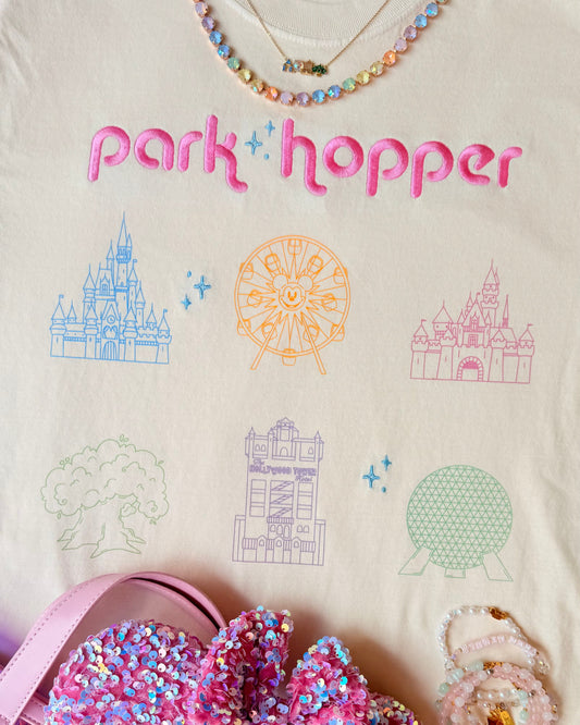 T-shirt with 'pork hopper' text and Disney castle designs, paired with Minnie Mouse ears and a pink bag.