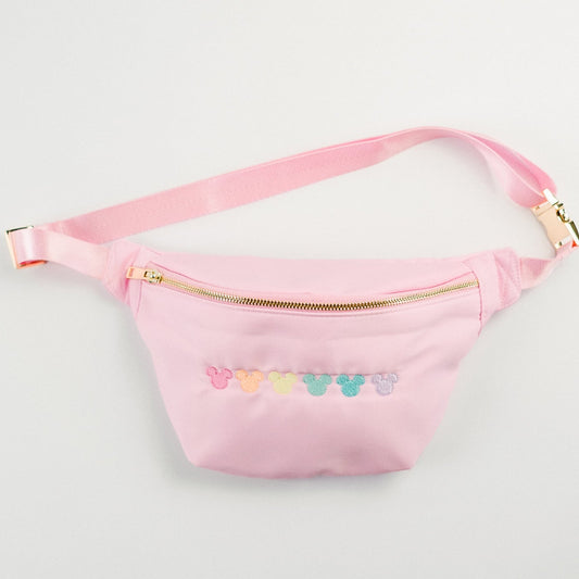 Pink fanny pack with colorful heart designs on a light gray background