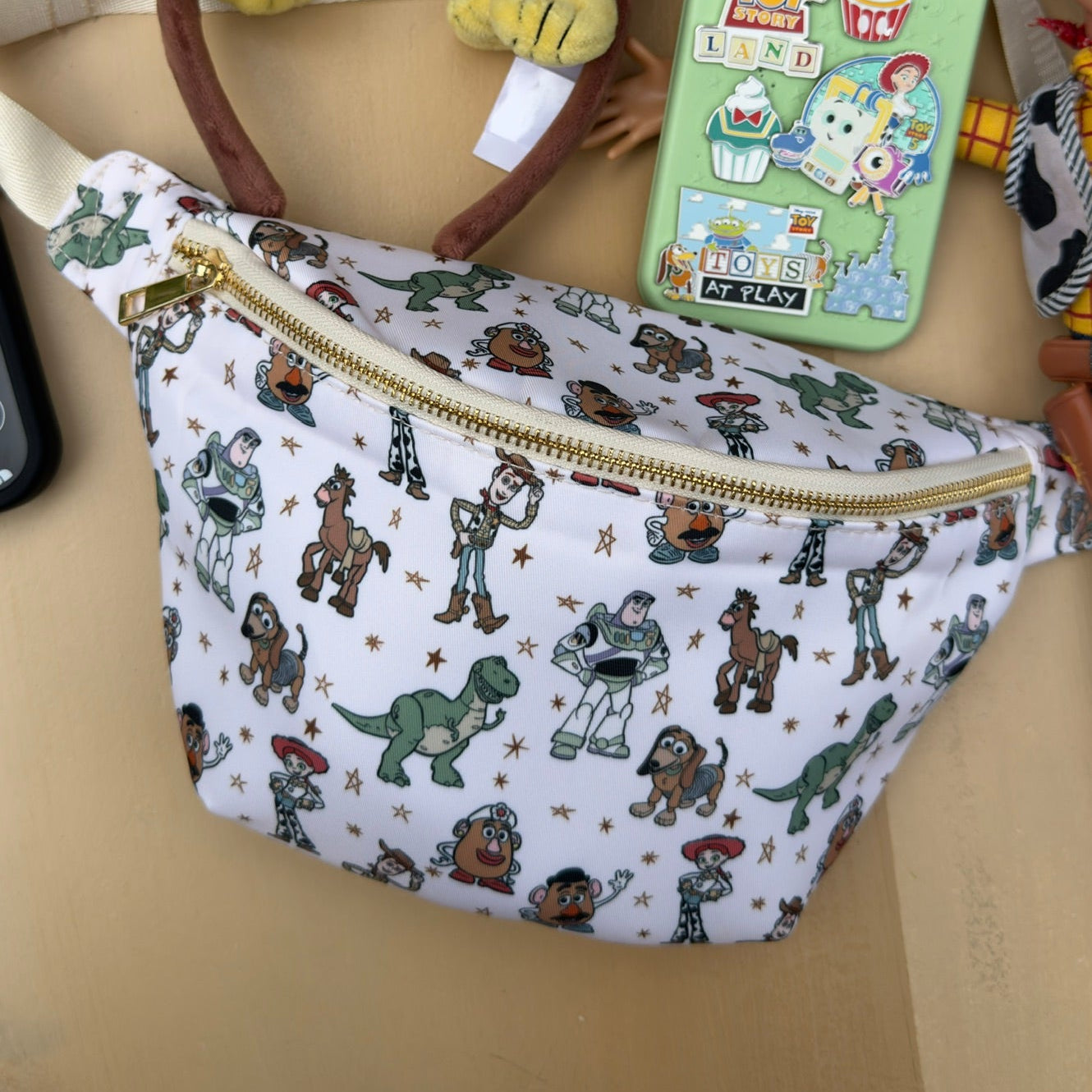 fanny pack with dinosaur pattern, headband, and pouch on a beige surface